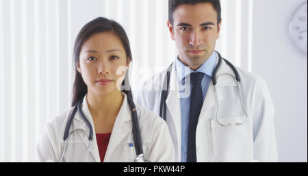 Zwei schwere Ärzte suchen an Kamera Stockfoto