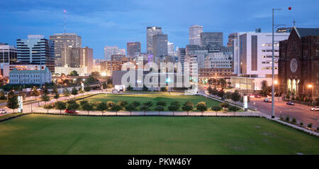 Downtown New Orleans ist eine belebte Gegend, die immer noch grünen Raum am Fuße des hohen Gebäuden unterhält Stockfoto