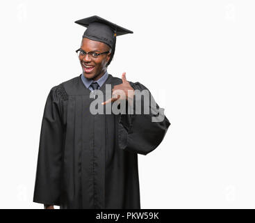 Junge graduierte afrikanische amerikanische Mann über isolierte Hintergrund lächelnd tun Telefon Geste mit der Hand und der Finger wie im Gespräch am Telefon. Communi Stockfoto