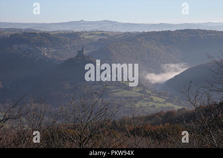 Najac Schloss und das Aveyron-tal im Herbst Morgen Sonne, mit Nebel im Tal. Stockfoto