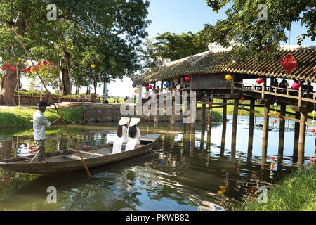 Zwei charmante Vietnamesische Mädchen in traditionellen weißen langen kleid sitzen auf dem Boot an Thanh Thuy Dorf in Hue, Vietnam Stockfoto