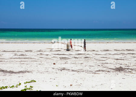 - GALU KINONDO, Kenia - 24. FEBRUAR 2018: Die kenianischen jungen Mann zu Fuß auf den Galu Kinondo - Strand in Kenia, Küste, bei Ebbe. Stockfoto