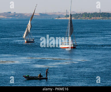 Die traditionellen Feluke segeln Boote mit lokalen ägyptischen Männer mit einem Fischernetz aus kleinen Ruderboot, Nil, Assuan, Ägypten, Afrika Stockfoto