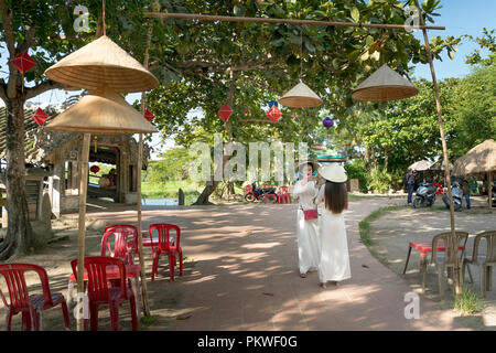 Zwei vietnamesische Mädchen sind sanft in der Kultur der traditionellen weißen langen Kleid ist unter Selbstporträt für jedes andere bei Thanh Thuy Chanh Dorf in Hue City Stockfoto