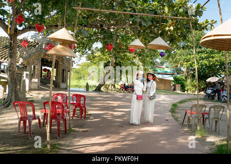 Zwei vietnamesische Mädchen sind sanft in der Kultur der traditionellen weißen langen Kleid ist unter Selbstporträt für jedes andere bei Thanh Thuy Chanh Dorf in Hue City Stockfoto