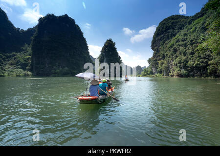 Die Touristen werden Reisen mit dem Schiff auf Ngo Dong Fluss in Wetland Nature Reserve in Ninh Binh, Vietnam Stockfoto