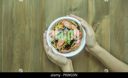 Spaghetti mit Wurst und getrocknete Paprika, würzig und scharf auf hölzernen Hintergrund, Ansicht von oben Stockfoto