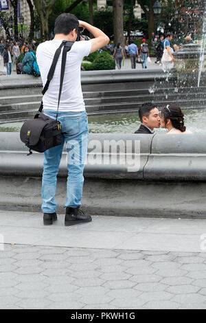 Eine Asiatische amerikanischen Fotografen fotografieren einen attraktiven chinesischen Paar vor der Hochzeit. Im Washington Square Park in Greenwich Villge, NYC. Stockfoto