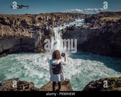 Frau bleiben Sie auf der Wasserfall in Island, versteckten Wasserfall in Island, erstaunlichen Sehenswürdigkeiten und Orte zu erkunden Stockfoto