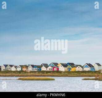 Die bunten Holzhütten am Mudeford Sandbank in der Nähe von Christchurch in Dorset. Stockfoto