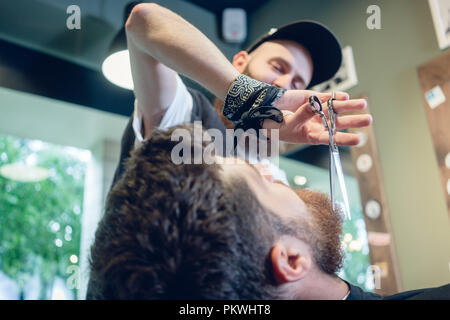 Nahaufnahme der Hand eines Friseur mit einer Schere beim Trimmen Stockfoto