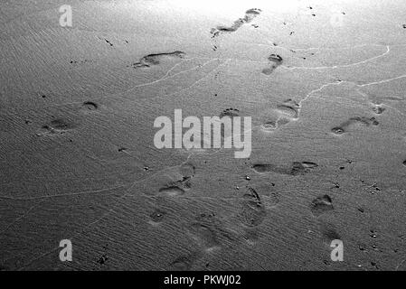 Schritte auf einem Sandstrand. Konzept : Minimalismus in der Fotografie. Stockfoto