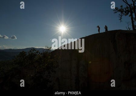 Silhouette von zwei Männer auf einem Berg mit einem Sonnenschliff oben. Pai Canyon Thailand Stockfoto