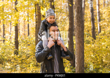 Vaterschaft, Kinder und Familie Konzept - der Vater seine Tochter Holding im Herbst Park Stockfoto