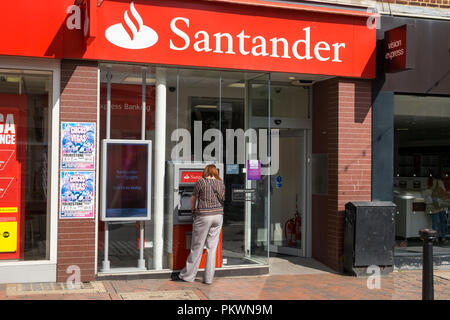 Santander Bank mit eine Frau an einem Geldautomaten, Ashford, Kent, Großbritannien Stockfoto