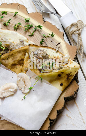 Pfannkuchen mit Pilzen und Thymian auf Holz- Hintergrund. Stockfoto