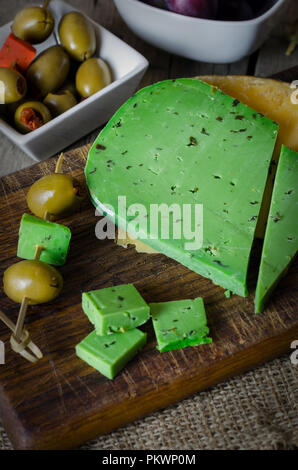 Grüne Käse mit Basilikum auf Holz- Hintergrund. Stockfoto
