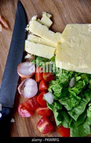 Home food Vorbereitung. Hausgemachtes Rindfleisch Burger, Pommes und Salat zubereitet in einer eigenen Küche. Bild zeigt Salat, Salat, Käse, Tomaten und Pommes Frites. Stockfoto