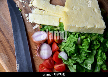 Home food Vorbereitung. Hausgemachtes Rindfleisch Burger, Pommes und Salat zubereitet in einer eigenen Küche. Bild zeigt Salat, Salat, Käse, Tomaten und Pommes Frites. Stockfoto