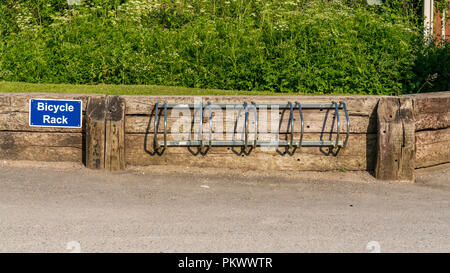 Ein Fahrrad Rack mit einem Schild, in Llanddulas, Conwy, Wales, UK gesehen Stockfoto