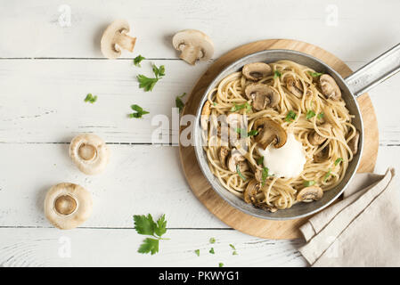 Pilz Spaghetti Pasta und Sauce auf weißem Hintergrund, Ansicht von oben. Hausgemachte italienische Pasta mit Champignon Pilze in der Küche pan. Stockfoto