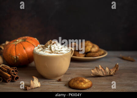 Pumpkin Spice Latte. Tasse Latte mit saisonalen Herbst Gewürze, Kekse und Fall Dekor. Traditionelle Kaffee Trinken für die Herbstferien. Stockfoto