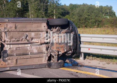 Der invertierte Auto nach dem Unfall liegt auf Ihrer Seite auf den Asphalt. Gefährliche Situation auf der Autobahn. Stockfoto