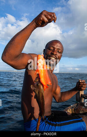 - GALU KINONDO, KENIA - Februar 26,2018: lokale Fischer mit einem Fisch in Galu Beach, Kenia. Jeden Morgen, mit einem Boot von Mango Tree, angeln gehen. Stockfoto