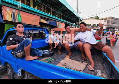 Cebu, Philippines-October 18, 2016: Bande von philippinischen Freunden feiern das Ende eines Arbeitstages lachen - sitzen auf der Ladefläche eines Pickup Truck. Kohlenstoff Stockfoto