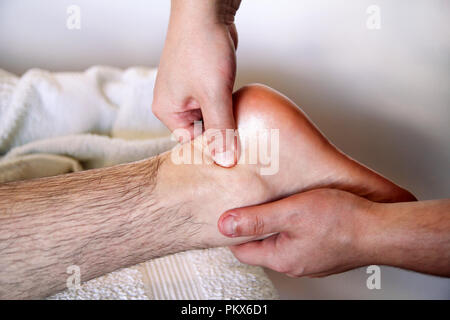 Massage studio entspannen. Fußmassage. Nahaufnahme des Fußes, die Massage in der Spa. Der Mensch empfängt Bein Massage. Therapeuten Hände massieren Männer Fuß. Stockfoto