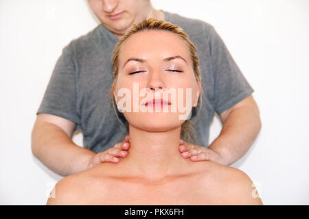 Massage studio entspannen. Frau in ihrem Nacken massiert durch einen Physiotherapeuten. Masseur massieren der Nackenmuskulatur. Körperpflege. Schöne junge Mädchen. Stockfoto