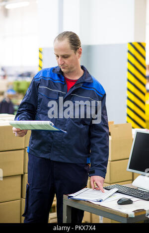 Fabrikarbeiter Schreibarbeit tun in einer Fabrik Lager Stockfoto