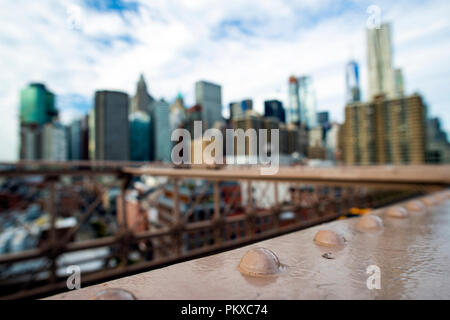 Verschwommen Manhattan Skyline von der schönen Brooklyn Bridge gesehen. Bewölkten Tag in New York City, USA. Stockfoto