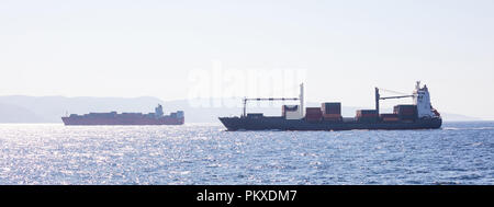 Zwei Containerschiffe für den internationalen Verkehr Segel voller Ladung. Meer Handel, blauer Himmel, Banner. Stockfoto