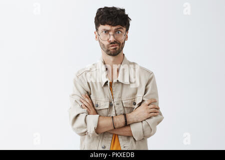 Taille-up Shot intensiver unzufrieden schöne Reife kaukasischen Typ mit Bart in beige Jacke, Hände auf die Brust grinsend und runzelte die Probleme auf der Arbeit denken und Zweifeln gekreuzt Stockfoto