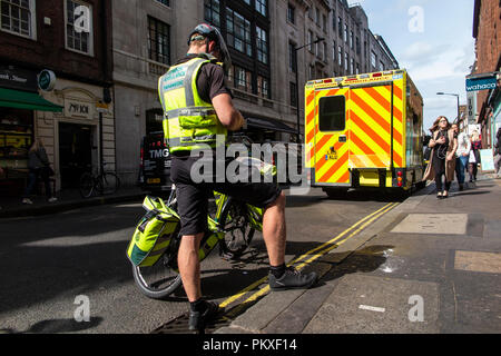 Ein Sanitäter mit dem Fahrrad hinter einem Krankenwagen in Soho geparkt, London Stockfoto