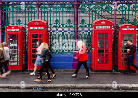 Iconic Telefonzellen in einem ikonischen Lage in der City von London mit unscharfen Passanten Stockfoto