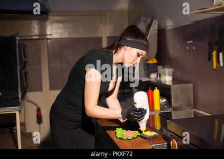 Frau Koch bereitet Burger Küche schön r Stockfoto