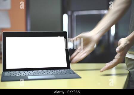 Hand tippen auf Laptop Tastatur angezeigte weißen Hintergrund. PC auf eine Tabelle in einem Büroraum. Stockfoto