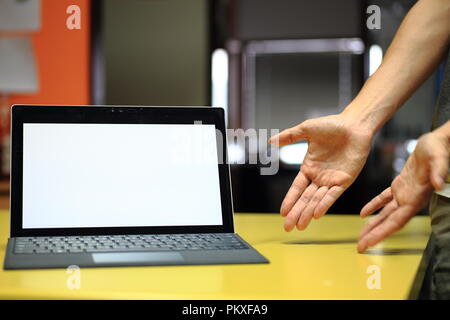 Hand tippen auf Laptop Tastatur angezeigte weißen Hintergrund. PC auf eine Tabelle in einem Büroraum. Stockfoto