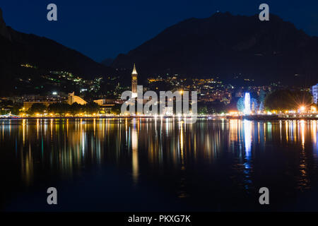 Nachtansicht von Lecco am Comer See mit den Bergen im Hintergrund, Italien wider Stockfoto