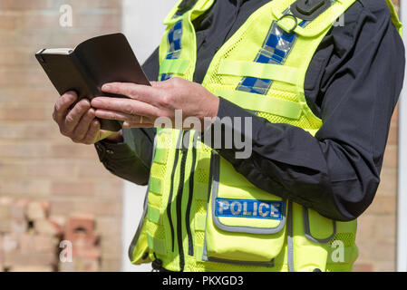 Nahaufnahme einer Frau, Polizei, Offizier, der Inhaber eines offenen schwarz Notebook, Stockfoto