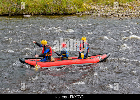 RIVER SPEY SCHOTTLAND DREI MENSCHEN WHITE WATER RAFTING IN EINEM Schlauchboot oder Kanu Stockfoto