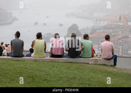 Porto, Portugal. 15. September 2018. Porto Touristen sitzt auf der Bank mit Blick auf den Fluss Douro in nebligen Tag im September Credit: WansfordPhoto/Alamy leben Nachrichten Stockfoto