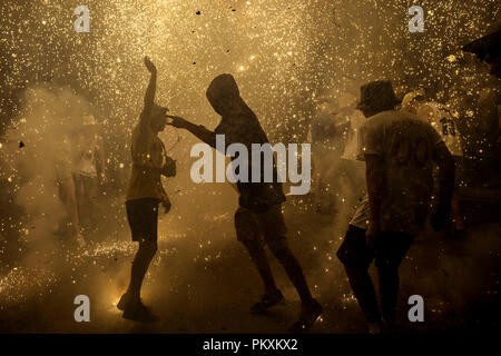 Sitges, Spanien. 15 September, 2018: Die Menge der Zuschauer tanzen unter den Funken aus der 'Correfocs' Verrechnung ihres Feuerwerk während Sitges "Santa Tecla' Festival Credit: Matthias Oesterle/Alamy leben Nachrichten Stockfoto