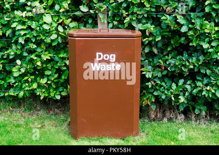 Hund Abfälle braun bin auf Grass gegen Hecke in Park sauber und ordentlich Stockfoto