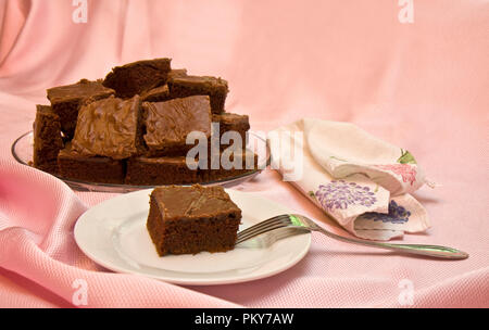 Chocolate brownies serviert auf Platte und auf Rosa drapiert Stoff isoliert Stockfoto