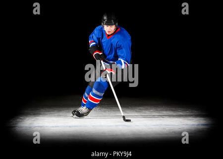 Junge hockey player mit Stick isoliert auf Schwarz Stockfoto