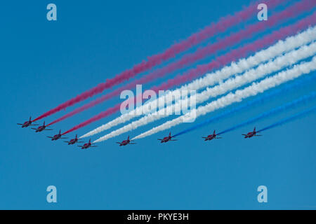 Die roten Pfeile tun ein Flypast in grossen neun Bildung trailing patriotischen Rauch auf Streitkräfte Tag in Llandudno Stockfoto