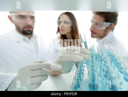 Hintergrund ist eine Gruppe von Wissenschaftlern, die studieren, die Flüssigkeit im Glas Rohr. Stockfoto